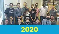 Equipe reunida em escritório com máscara, destacando o ano de 2020.