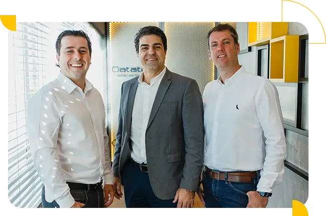 Sócios da Datatem posando juntos em um ambiente corporativo.